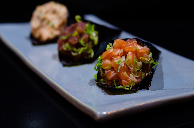 Peças de sushi e sashimi de salmão dispostas sobre ardósia